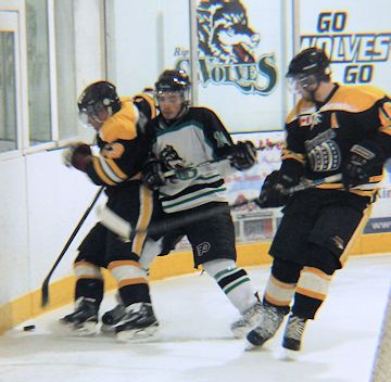 Cody Britton (C) of the Wolves, pushes for control of the puck